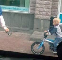 Foto de criança com coleira enquanto anda de bicicleta provoca polêmica
