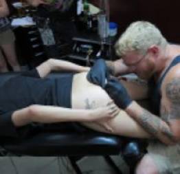 Safada com pircing na buceta faz tatuagem no cu