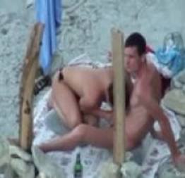 Mulher pagando boquete na praia de nudismo