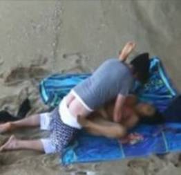 Casal de namorados dando uma cravada na praia