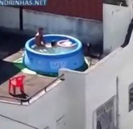 Filmando a trepada na piscina de plastico no terraço