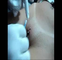 Gostosa colocando piercing