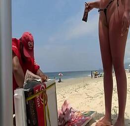Na praia provocando o vendedor de geladinho com seu corpo